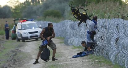 Inmigrantes cruzan la frontera entre Hungría y Serbia ante la policía.