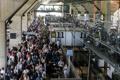 Miles de personas hacen fila para conseguir entrar a un taxi en el aeropuerto Madrid-Barajas.