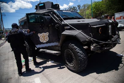 Policías inspeccionan el vehículo acorazado que recuperaron tras el acuerdo entre el Estado y los manifestantes.