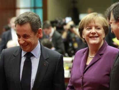 Merkel habla con Sarkozy (dcha) y Durao Barroso.