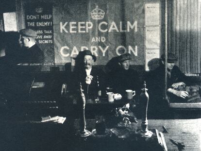 Varios hombres en un pub de Londres, en 1941, con el cartel de 'Keep Calm and Carry On'.
