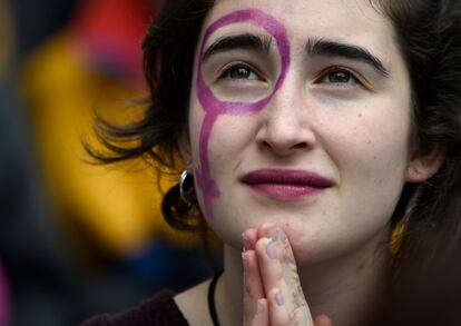Una chica con el símbolo de Venus pintado en la cara durante la manifestación por el Día Internacional de la Mujer en Barcelona.