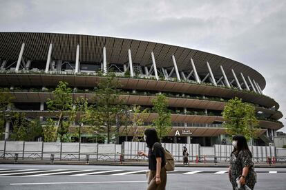 Dos personas pasean al lado del Estadio Nacional de Japón, en Tokio.