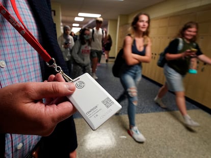 The security director of a Kansas school displays a panic button to be used in an emergency.