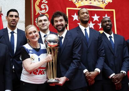 La presidenta de la Comunidad de Madrid, Cristina Cifuentes (2i), junto al base Sergio Llull (3d) y los jugadores Ayón, Maciulis, Randolph y Othello Hunter (i-d), posa para la foto de familia con el trofeo durante el homenaje que han recibido los jugadores del Real Madrid de baloncesto en la sede de la Comunidad, tras proclamarse campeones de la Copa del Rey, el 20 de enero de 2017.