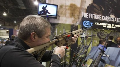 Un hombre prueba una Colt M4 en una feria de Las Vegas.