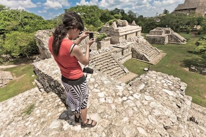 Una turista fotografía las ruinas mayas de Ek Balam (México).