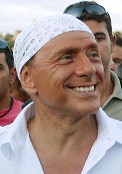 Silvio Berlusconi luce su <i>bandana.</i>
