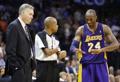 Mike D'Antoni escucha como Kobe Bryant trata de explicarle al árbitro su defensa después de que este le hubiera pitado una falta.