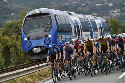 El pelotón circula junto a un tren durante la primera etapa.