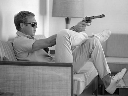 Steve McQueen, sentado en el sofá de su casa de Palm Springs (California) con una pistola en la mano, en mayo de 1963.