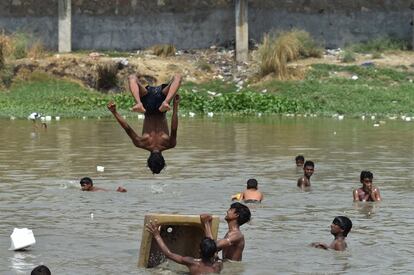 Un grupo de niños se refrescan del calor en Nueva Delhi , India.