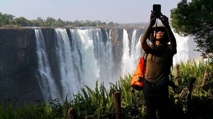 Una turista se fotografía en el lado zimbabués de las cataratas Victoria, formadas por el río Zambeze.