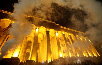 Manifestantes prenden bengalas durante una protesta contra el gobierno frente al Parlamento en Tbilisi (Georgia).