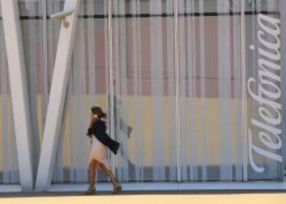 Una mujer pasea junto a la sede de Telef&oacute;nica en Barcelona.