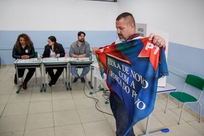 Un seguidor de Lula Da Silva, despliega una bandera en apoyo al Partido del Trabajo al terminar de emitir su voto.