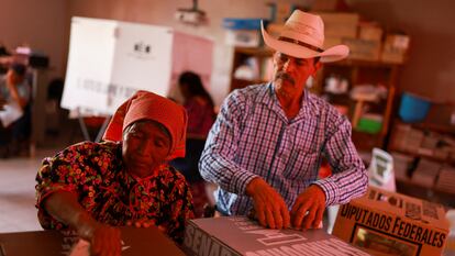 Una mujer indígena rarámuri y un hombre depositan su voto en una casilla electoral en el pueblo de Norogachi (Chihuahua), el 2 de junio de 2024.