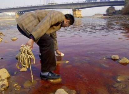 Un miembro del departamento local para la protección del medioambiente recoge agua del río Amarillo.