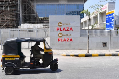 Un rickshaw pasa ante la sede de Jio en Bombay.