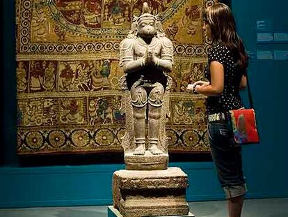 Escultura del dios mono Hanuman, del siglo XVI, ante un tapiz con escenas del <i>Maha-Bhaarata. </i>