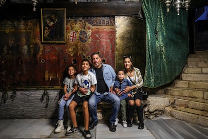 Jack Abdallah, su mujer y sus hijos en la gruta del nacimiento en la Basílica de la Natividad. Se han trasladado a Jerusalén por la dificultad que implica llegar hasta allí desde Belén, más del doble de kilómetros y atravesar desde el sur un control del ejército que no siempre está abierto