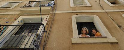 La barcelonesa Montse Perez y su hija Thais Franco en una ventana del piso de su propiedad que ha tenido que alquilar a través de Airbnb para poder recuperarlo después de alquilárselo a un arrendatario.