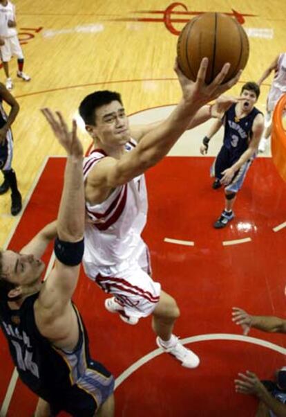 El <i>pívot</i> chino de los Rockets de Houston, Yao Ming, entra a canasta ante Gasol (a la izqda.).