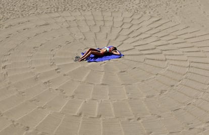 Una mujer toma el sol en una playa en Cannes, Francia.