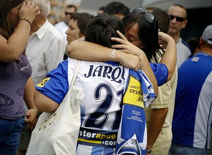 Dos seguidoras del Espanyol, una de ellas con la camiseta de Jarque, se abrazan en la puerta 21 del estadio.