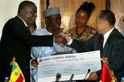 El primer ministro chino, Li Zhaoxing, entrega una donación de 200.000 dólares a su homólogo senegalés, Cheikh Tidiane Gadio, el jueves en Dakar.