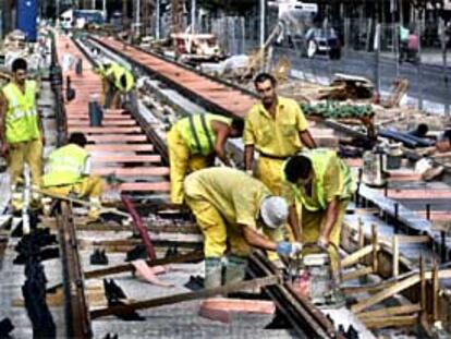 Operarios trabajando en la colocación de las vías del tranvía en la Diagonal barcelonesa.