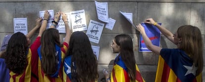 Varias estudiantes pegan carteles en la pared de la Universidad de Barcelona durante el inicio de la "Maratón por la democracia".