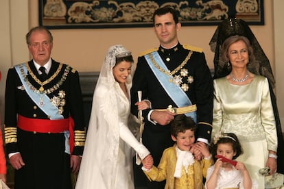 Los hijos de la infanta Elena, Felipe y Victoria Federica, posan con los novios y los reyes eméritos. El menú del banquete nupcial, del restaurante Jockey (que llevaba 18 años sirviendo las cenas de gala en el Palacio Real), consistió en entrantes variados, con jamón de Jabugo, queso manchego con regañadas, tartaletas de 'esqueixada', canapés de gamonedo con manzanas, 'mousse' de pescado de roca, patatas rellenas de changurro, vieiras fritas empanadas, tostas de champiñón, puntas de espárragos verdes fritas y tirabuzones de lenguado. Eso de aperitivo. De comida, tartaleta de hojaldre con frutos de mar y capón asado en tomillo, frutos secos, tarta (de dos metros de altura) y café. Los vinos, españoles, blanco Rías Baixas y Rioja Gran Reserva de 1994. 