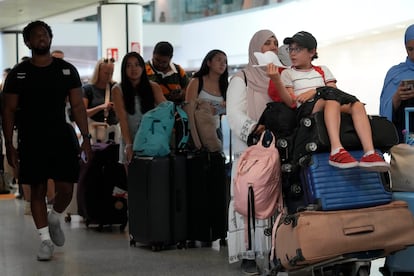 Un grupo de pasajeros esperan a sus vuelos internacionales en el aeropuerto Roma-Fiumicino, este viernes