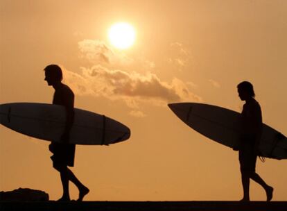 Dos surfistas de camino a la playa