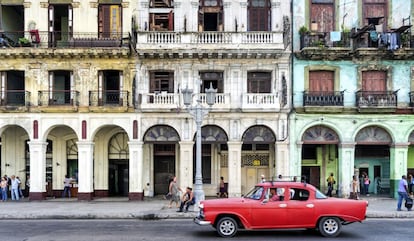 Un coche en el malecón de la Habana (Cuba), frente a unas casas.
