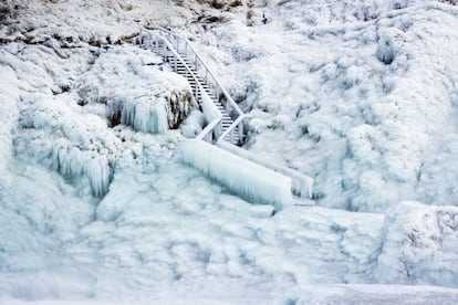 La nieve congela un sendero público de un jardín cercano a una cascada de Islandia.