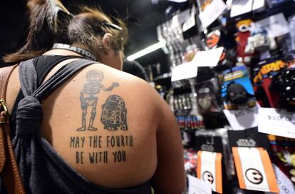 Una fanática muestra su tatuaje de Star Wars (con C3PO y R2-D2) durante su visita a la apertura de la convención este 26 de abril.