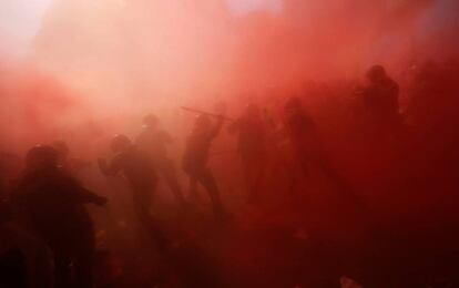 Manifestants i mossos embolicats en un núvol de pols.