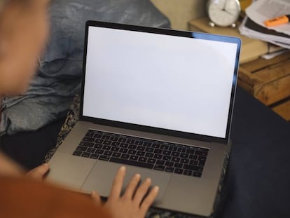 Una mujer, ante una pantalla en blanco del ordenador.