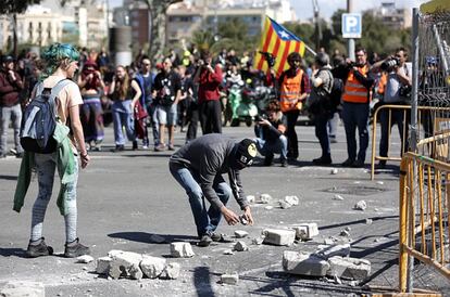 Manifestantes independentistas cogen piedras en la calle Tarragona durante el acto de Vox en la capital catalana.