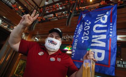 Un partidario de Trump posa para una foto en un bar.