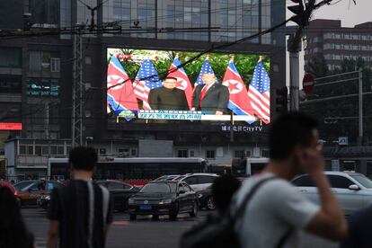 Una gran pantalla, situada en una plaza de Singapur, retransmite la reunión entre Donald Trump y Kim Jong-un.