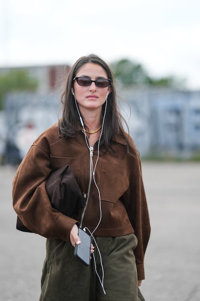 Una de las asistentes a la Copenhague Fashion Week con cascos blancos de cable.
