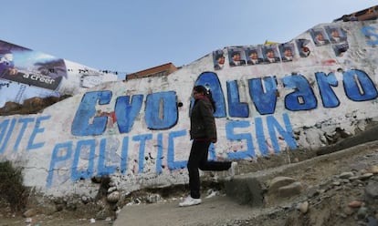 Una mujer camina frente a una pintada en El Alto (Bolivia). 