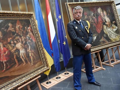 Un policía alemán custodia dos cuadros de Jacob Waben recuperados en la embajada holandesa en Kiev.