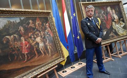 Un policía alemán custodia dos cuadros de Jacob Waben recuperados en la embajada holandesa en Kiev.