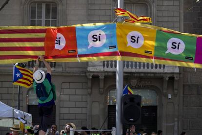 Un hombre coloca unas banderas a favor del referémdun del 1-O en el paseo de Gràcia.