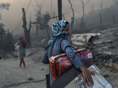 Una mujer traslada sus pertenencias tras el incendio, este miércoles.