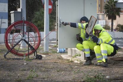 Dos trabajadores ajenos al conflicto del metal se protegen tras encontrarse entre los trabajadores del metal y las fuerzas de seguridad, este viernes.